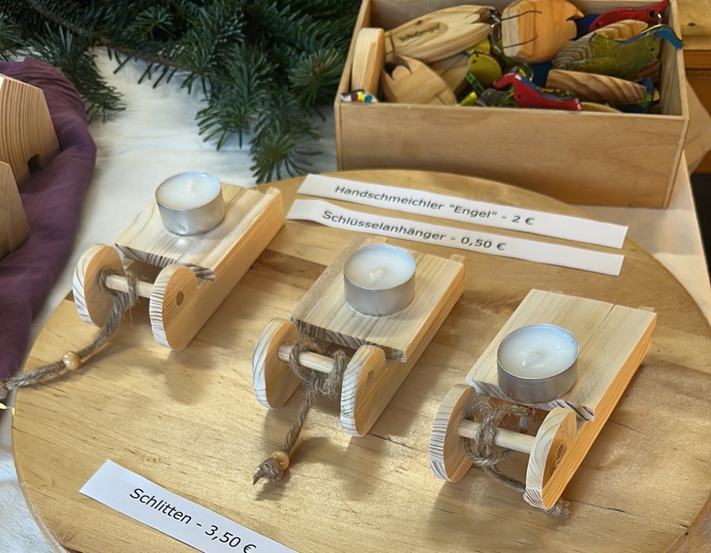 Aus Holz gefertigte Schlüsselanhänger und kleine Holzschlitten.