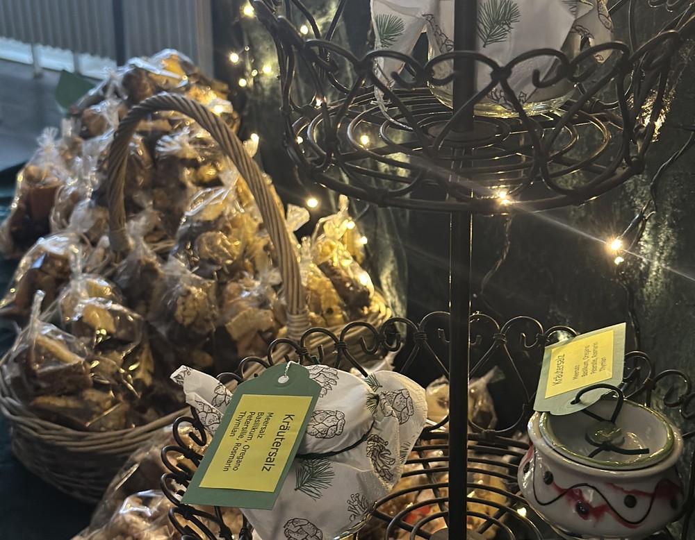 Weihnachtskekse in einem Korb sowie Kräutersalz auf Servierplatten.