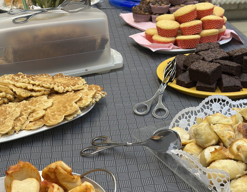 Ein Tisch ist gedeckt mit Waffeln, Brownies, Muffins und Käselaugenteilen