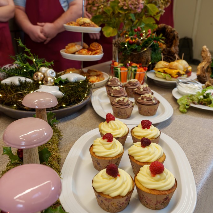 Ein festlich dekorierter Tisch zu Weihnachten mit Muffins, Hamburgern und herzhaften Blätterteig-Schnecken. (vergrößerte Bildansicht wird geöffnet)
