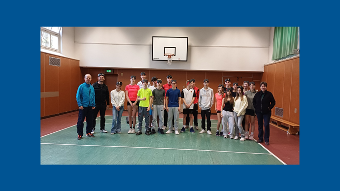 Lehrerinnen, Lehrer sowie Schülerinnen und Schüler, die sich in der Turnhalle versammelt haben