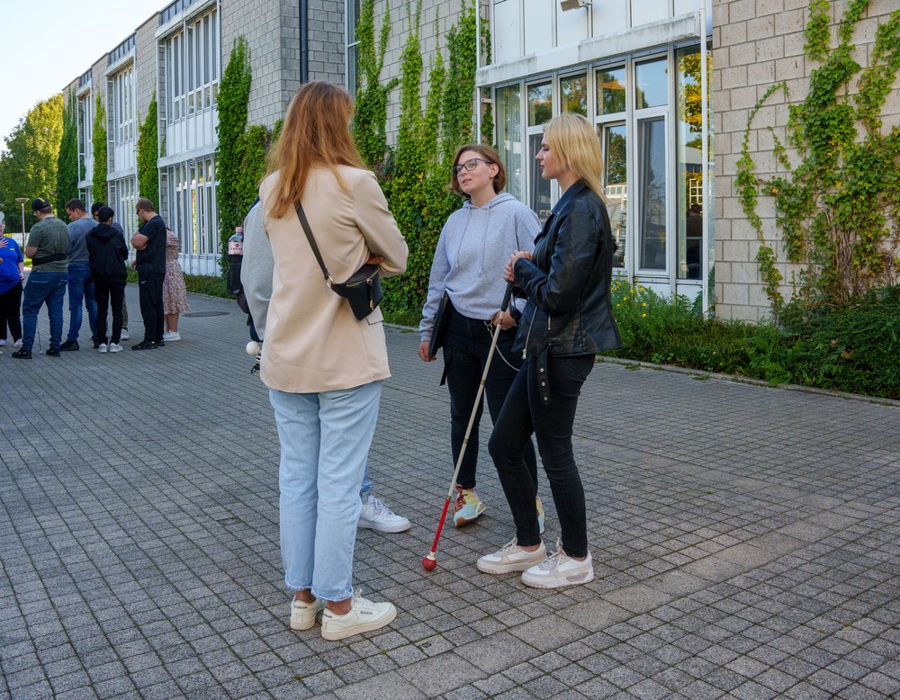 Vor dem Schuleingang stehen einige Schülerinnen