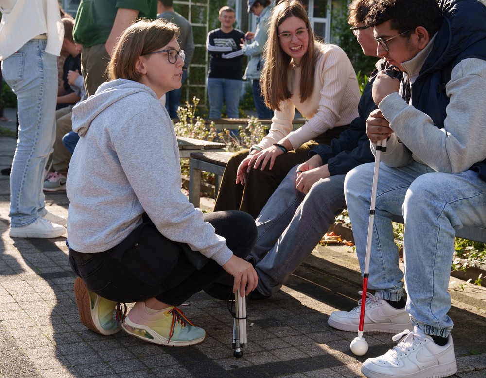 Die MPT-Kraft führt ein Gespräch mit einem Schüler, der auf einer Bank sitzt.