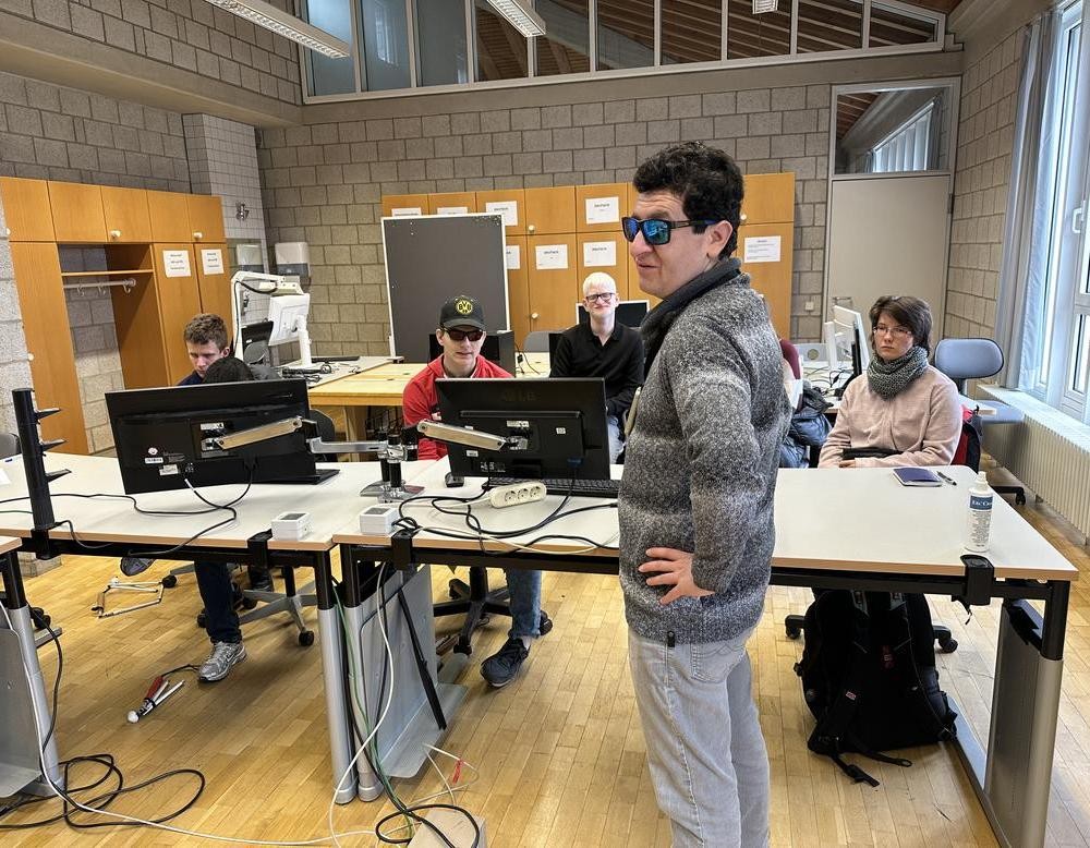 Der Referent steht vorne, während die Schülerinnen und Schüler sitzen und aufmerksam zuhören