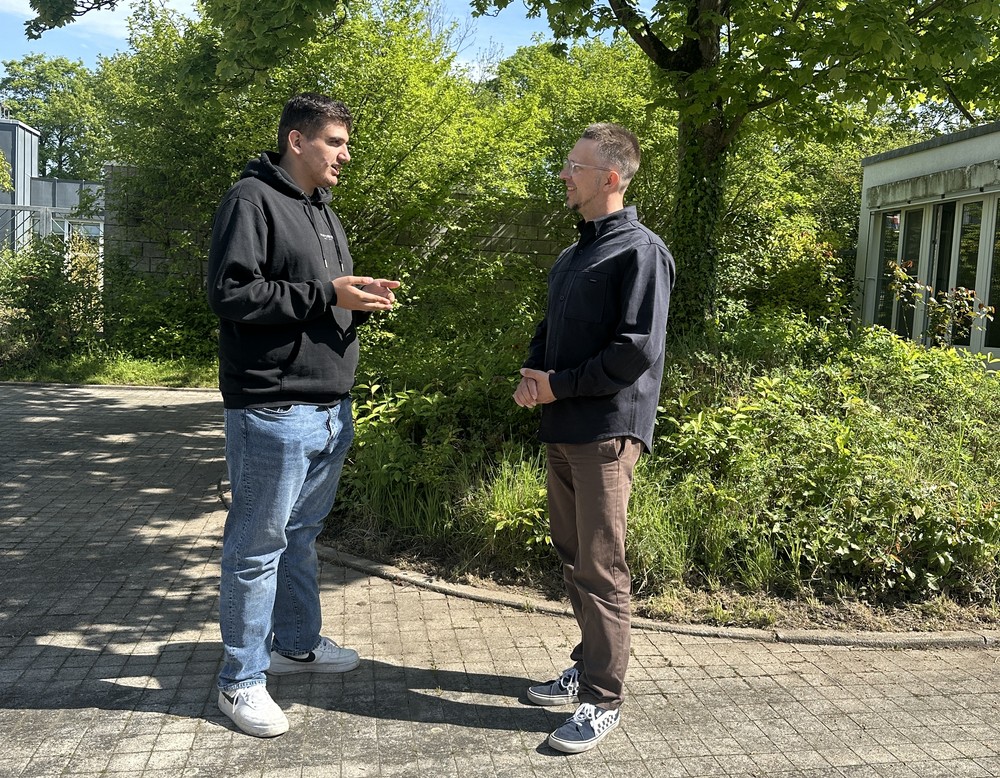 Schulsozialarbeiter im Gespräch mit Schülern auf dem Pausenhof.