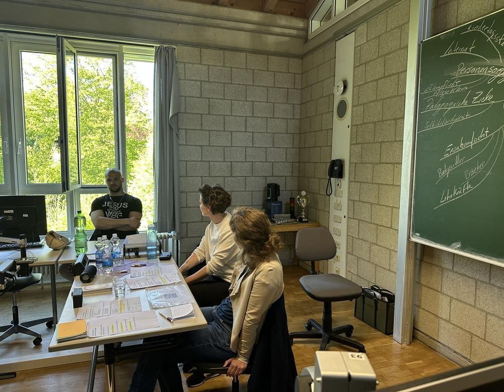 Referentinnen sitzen vor Schüler und erklären etwas.
