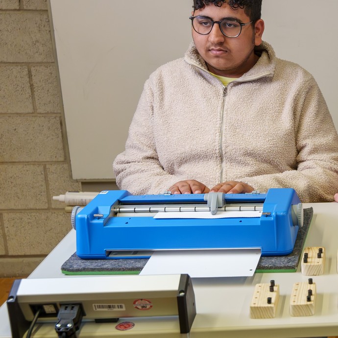 Schüler an der Punktschriftmaschine (vergrößerte Bildansicht wird geöffnet)