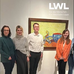 Direktorin steht neben zwei Schülerinnen und ein Schüler im Museum