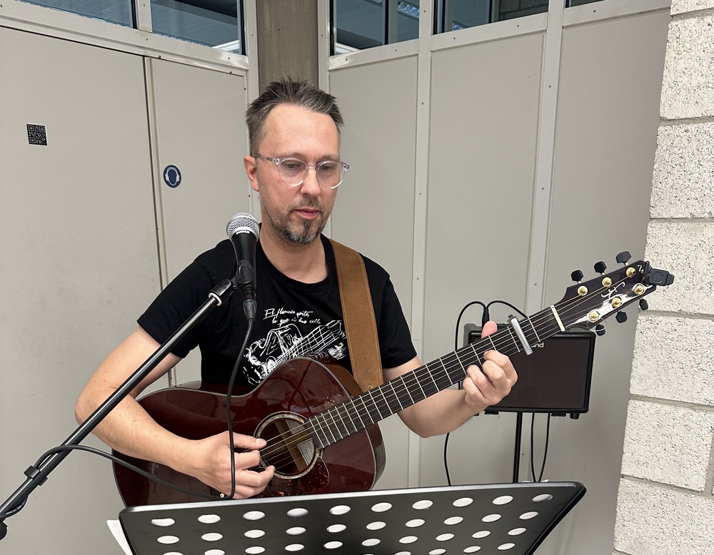 Der Schulsozialarbeiter spielt mit eine Gitarre Weihnachtslieder.