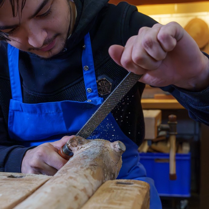 Schüler arbeitet mit Raspeln und Feilen an einem Holzstück (vergrößerte Bildansicht wird geöffnet)